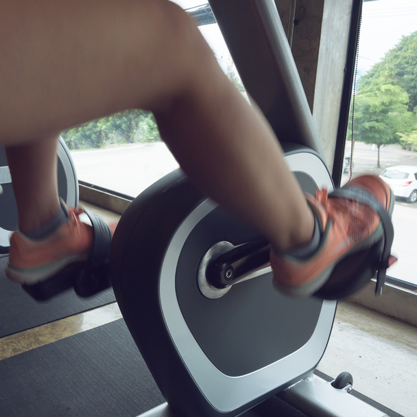 woman exercise riding bicycle in fitness center - Photo, Image