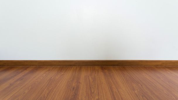 empty room with brown wood laminate floor and white mortar wall  - Photo, Image