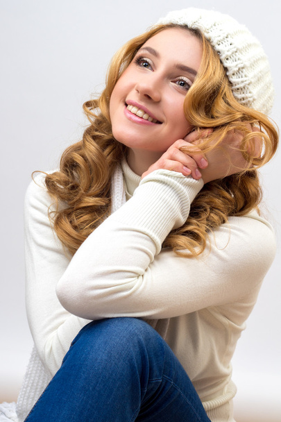 close-up portrait of a blonde girl in a warm white pullover and hat isolated on white background - Foto, Imagem