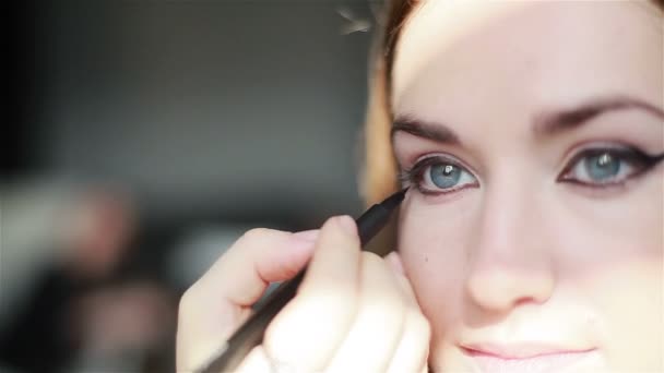 Ammattimainen meikkitaiteilija soveltamalla siivekäs eyeliner. lähikuva
 - Materiaali, video