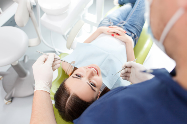 Experienced young dental doctor is examining female teeth - Fotó, kép