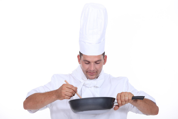 Chef stirring contents of saucepan - Fotoğraf, Görsel