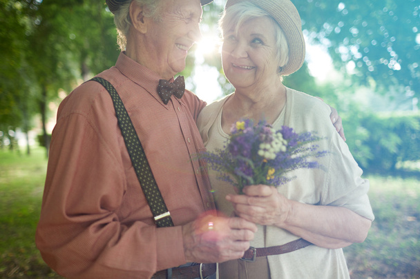 Šťastný starší pár s květinami - Fotografie, Obrázek