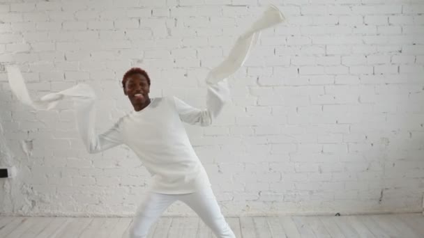 An insane black man in his forties wearing a straitjacket dance and have fun - Imágenes, Vídeo