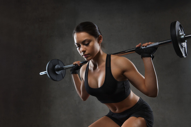 jovem mulher flexionando músculos com barbell no ginásio
 - Foto, Imagem