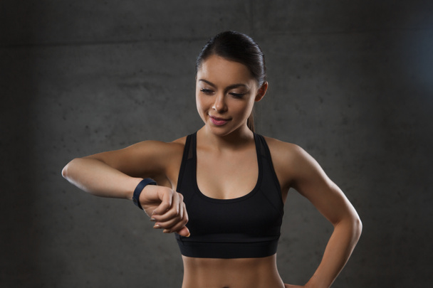 Młoda kobieta z tętna zegarek w siłowni - Zdjęcie, obraz