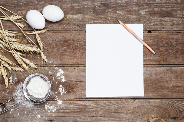 The flour  and eggs on an wooden background - Foto, afbeelding