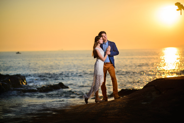 Ζευγάρι στην αγάπη βλέποντας ένα ηλιοβασίλεμα στην παραλία - Φωτογραφία, εικόνα