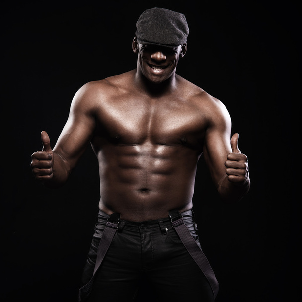 Portrét atletické afroamerické muže nahoře bez. Pouze v podvazky a čepici - Fotografie, Obrázek