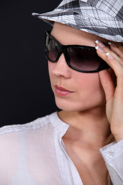 Portrait of young woman with sunglasses and cap - Foto, afbeelding
