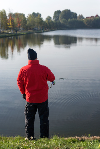 Homem pescando em um lago ao pôr do sol
. - Foto, Imagem