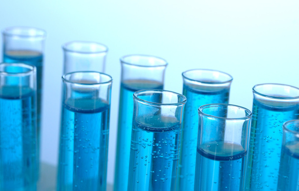 Tubos de ensayo con líquido azul sobre fondo azul
 - Foto, Imagen