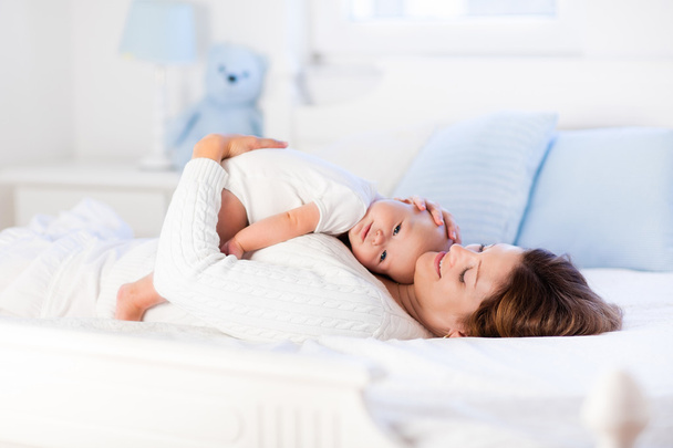 Mutter und Baby auf einem weißen Bett - Foto, Bild