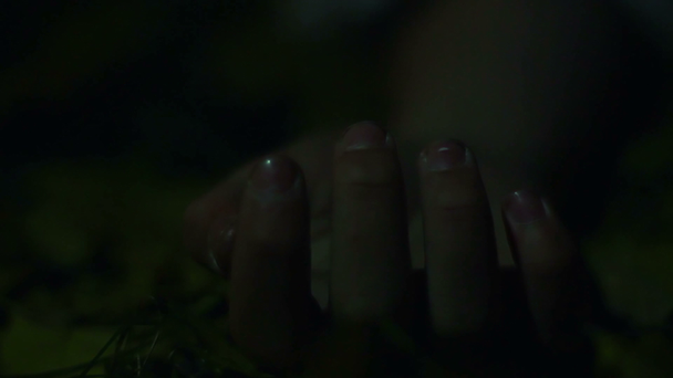 Closeup of dead person's hand, unidentified corpse lying on ground, crime scene - Felvétel, videó