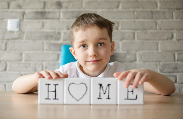 Dítě hraje s kostkami a dává dohromady v slovo "domov". - Fotografie, Obrázek