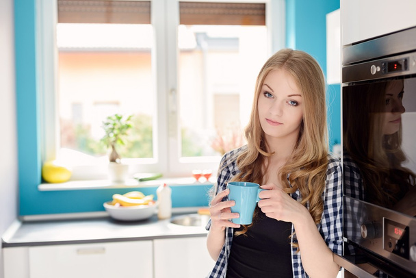Young blond woman drinking tea or coffee - Zdjęcie, obraz