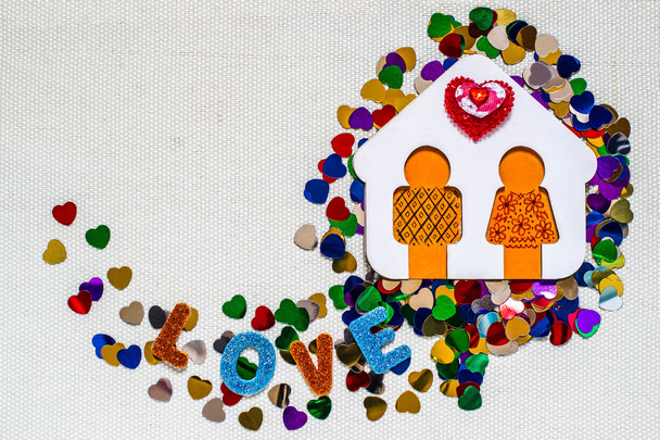 Casa de madeira com homenzinho e confete brilhante em forma de coração
  - Foto, Imagem
