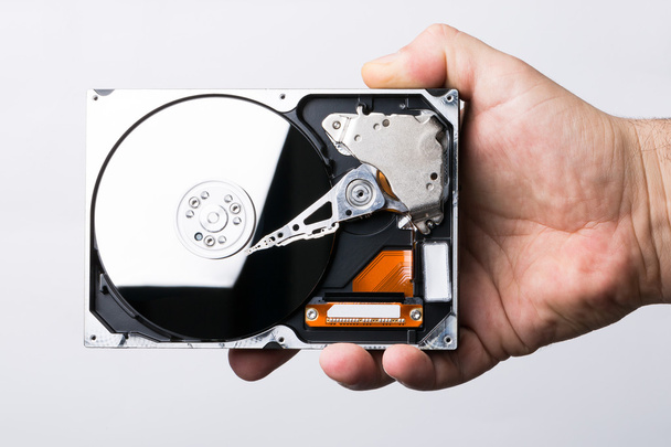 Male technician hand holding computer hard drive over white back - Photo, Image