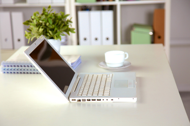 Vue rapprochée d'un intérieur de bureau avec un ordinateur portable, une tasse de café et des rideaux blancs par une journée ensoleillée
 - Photo, image