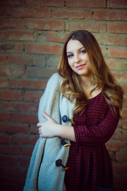 beautiful girl portrait white sweater brick background - Foto, immagini