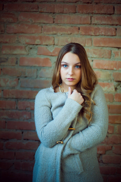 beautiful girl portrait white sweater brick background - Photo, Image