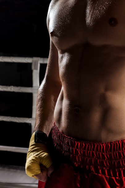 Cheerful male fighter is training in gym - Фото, зображення