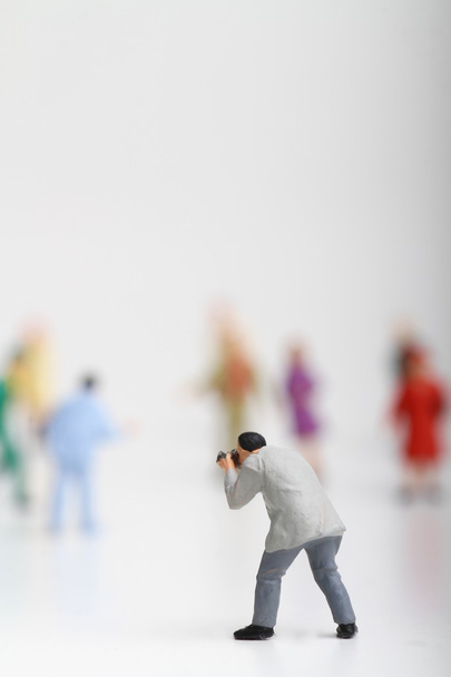 Miniatura de um fotógrafo de rua tirar fotos de estranhos andando sobre ta fundo branco
 - Foto, Imagem