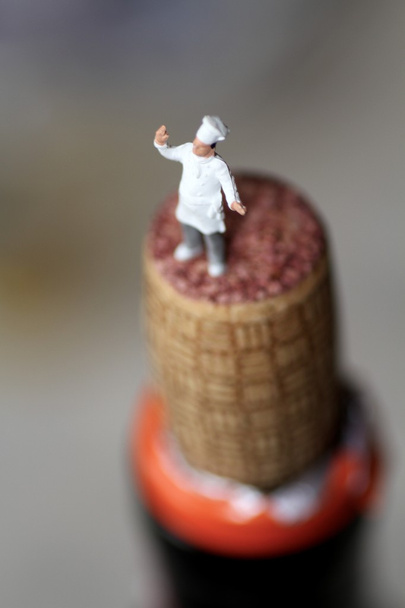 Chef en miniatura sobre el corcho de una botella de vino
 - Foto, Imagen