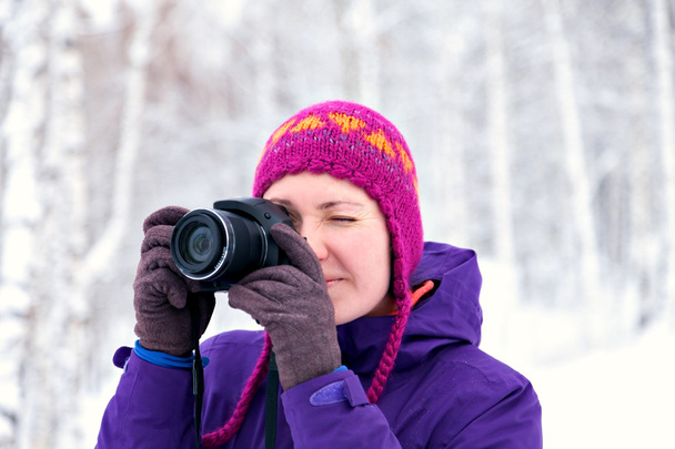 Girl with camera in winter forest photographed. - Фото, зображення