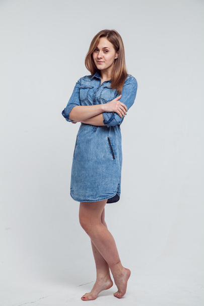 Portrait of a girl in a blue denim dress - isolated on white background - Foto, afbeelding