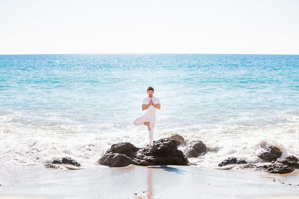 asiatischer Mann steht in Yoga-Pose am Strand - Foto, Bild