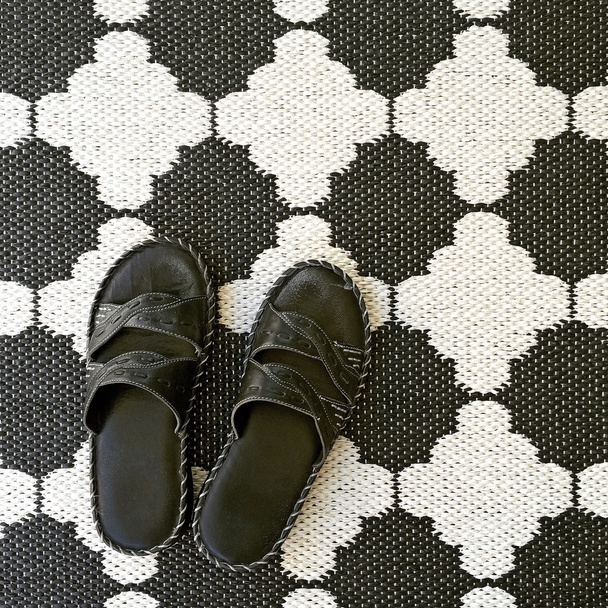 Sandales en cuir sur tapis noir et blanc
 - Photo, image