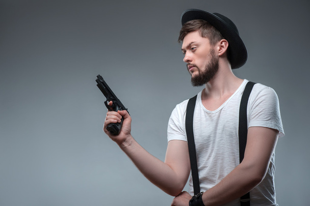 Cheerful young man with weapon and cap - Foto, Imagem