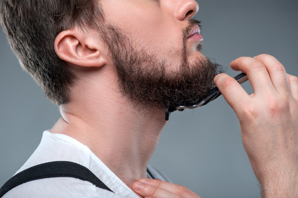 Healthy bearded young guy with sharp razor - Foto, afbeelding