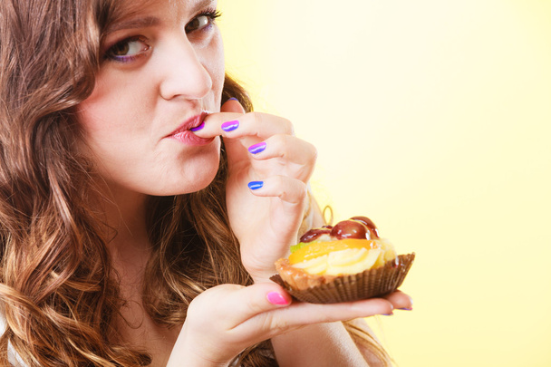 Closeup flirty woman eating fruit cake - Photo, image