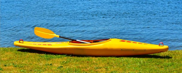 Kayak giallo sulla riva del fiume
 - Foto, immagini
