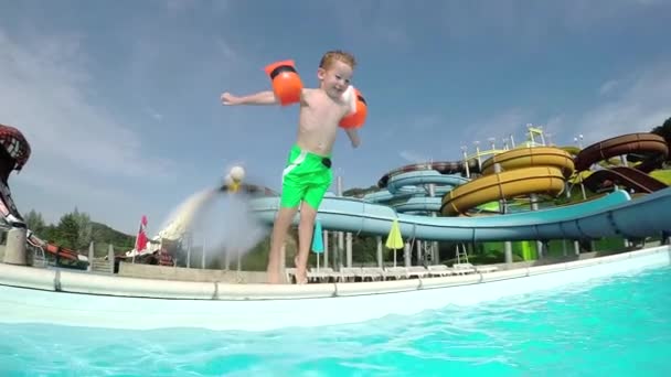 Щаслива дитина посміхається і стрибає у воду в басейні
 - Кадри, відео
