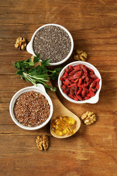 Super food - goji berries, chia seeds, flax seeds, walnuts and omega-3 capsules - Foto, Bild