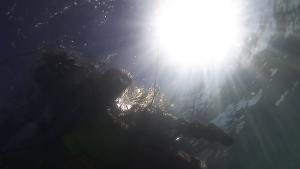 太陽を背景に水の外のボートの下. - 映像、動画