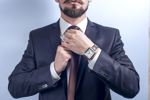 Bearded man straightens his tie - Fotoğraf, Görsel
