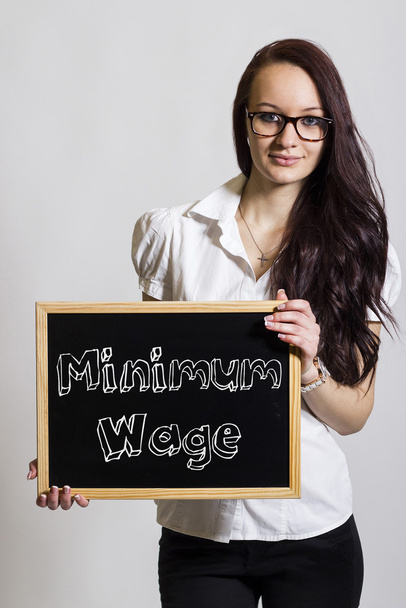 Salaire minimum - Jeune femme d'affaires tenant un tableau noir
 - Photo, image