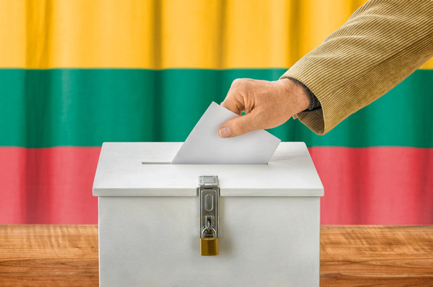 Мужчина кладет бюллетень в урну для голосования - Литва
 - Фото, изображение