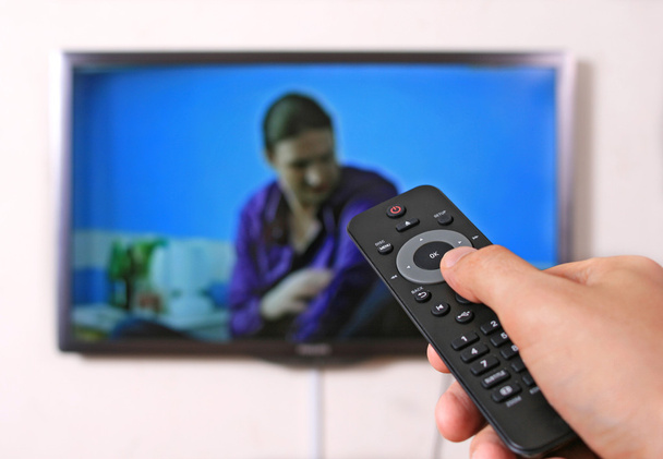 Remote control in man's hand and TV set - Photo, Image