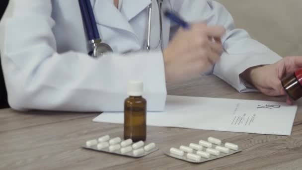Az orvos néz ki a gyógyszert, és azt írja a recept. - Felvétel, videó