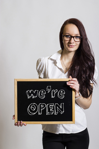 We're OPEN - Young businesswoman holding chalkboard - Photo, Image