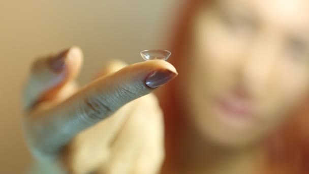 Lente de contacto: Mujer joven sosteniendo la lente de contacto en el dedo delante de su ojo
 - Imágenes, Vídeo