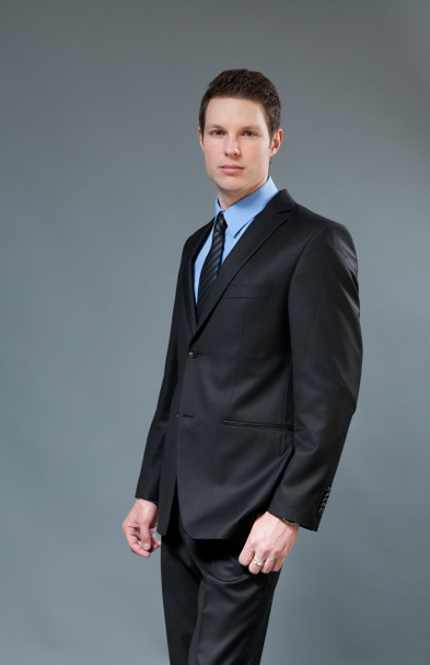 Young businessman wearing classic dark suit. Half-turn studio shot. One of a series. - Foto, immagini