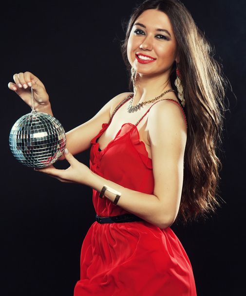 Young  woman in red dress keeping disco ball - Φωτογραφία, εικόνα