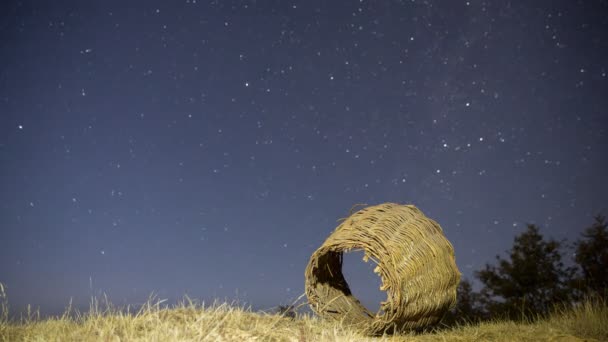 4k éjszakai idő telik el a csillagok és a kivilágított rozsdás fonott kosár - Felvétel, videó