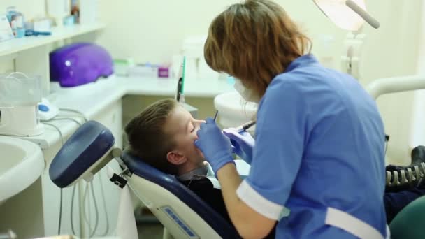 Closeup beetje kid tijdens procedure van tanden boren behandeling bij het kantoor van de tandarts kliniek. - Video